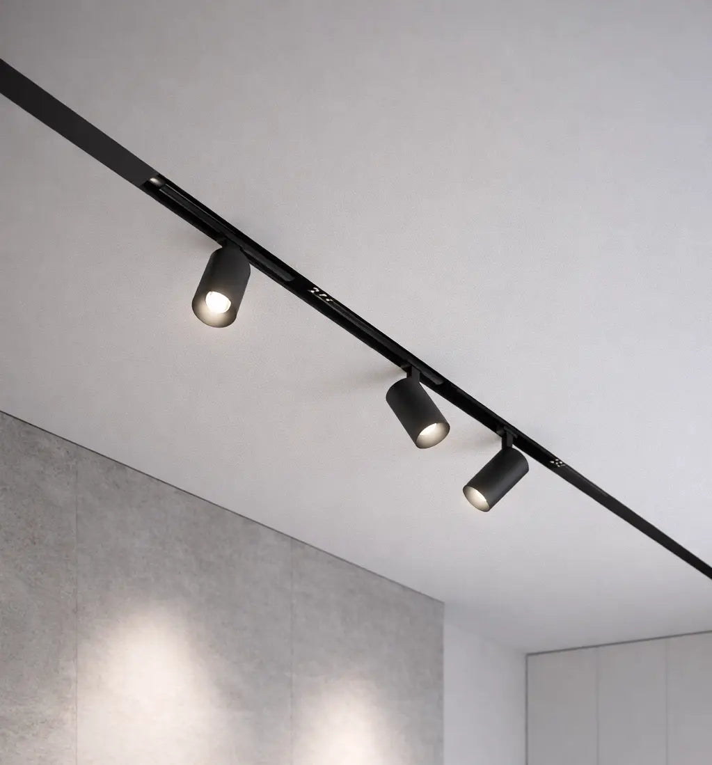 Binario magnetico 48V con spot orientabili neri installato a soffitto per illuminazione direzionale su parete